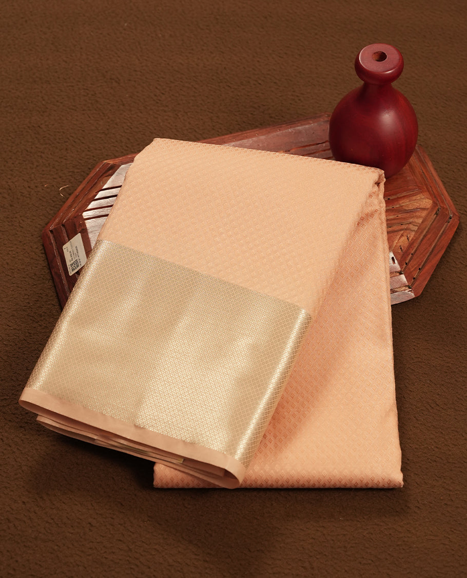 Light peach colour semi soft silk saree featuring a self coloured tiny diamond patterned body, complemented by Gold colour traditional pallu with tiny diamond pattern and border and a matching blouse piece.