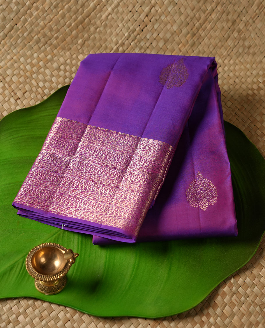 Indigo colour Vasundhara silk saree adorned with all-over gold motifs on the body, complemented by a self colour with gold tarditional border and paired with a matching blouse piece.