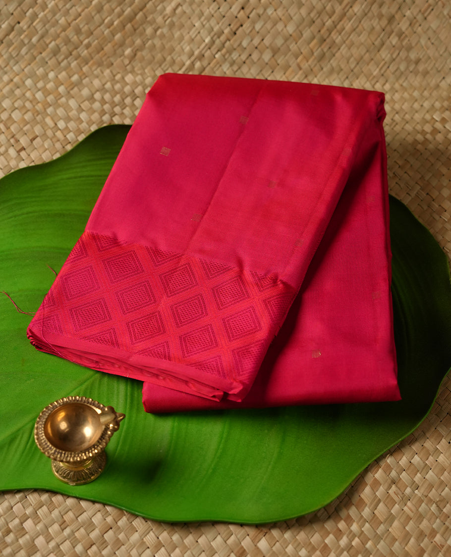 Rani pink colour Vasundhara silk saree adorned with all-over gold square motifs on the body, complemented by a self colour with box pattern on border and paired with a matching blouse piece.