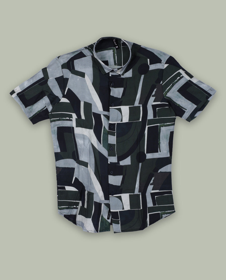 Dark green colour shirt featuring bold abstract geometric prints in shades of black, white, and grey & Designed with a classic collar and short sleeves, it offers a trendy, artistic look perfect for casual outings.