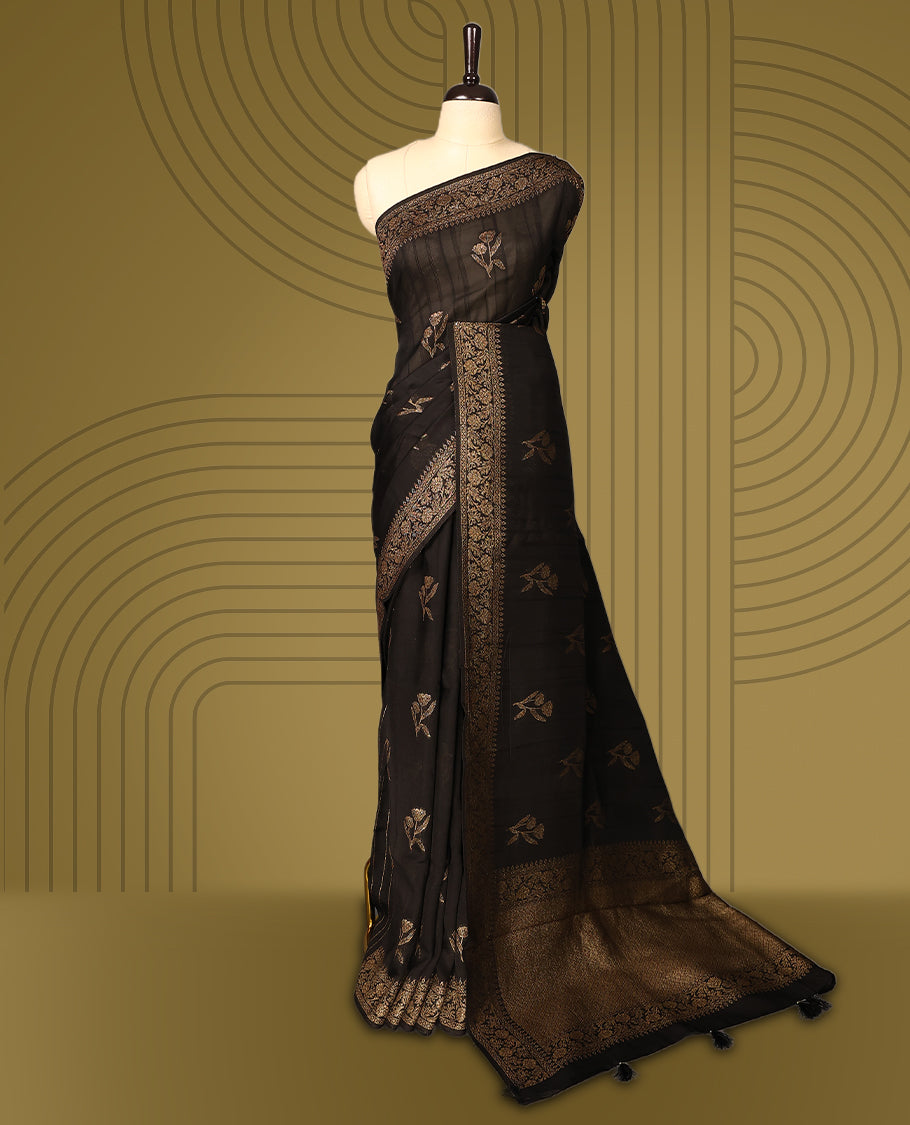 Black semi Banaras tussar saree adorned with golden floral motifs along the border and scattered designs across the body, finished with a rich golden zari pallu, paired with a matching blouse.
