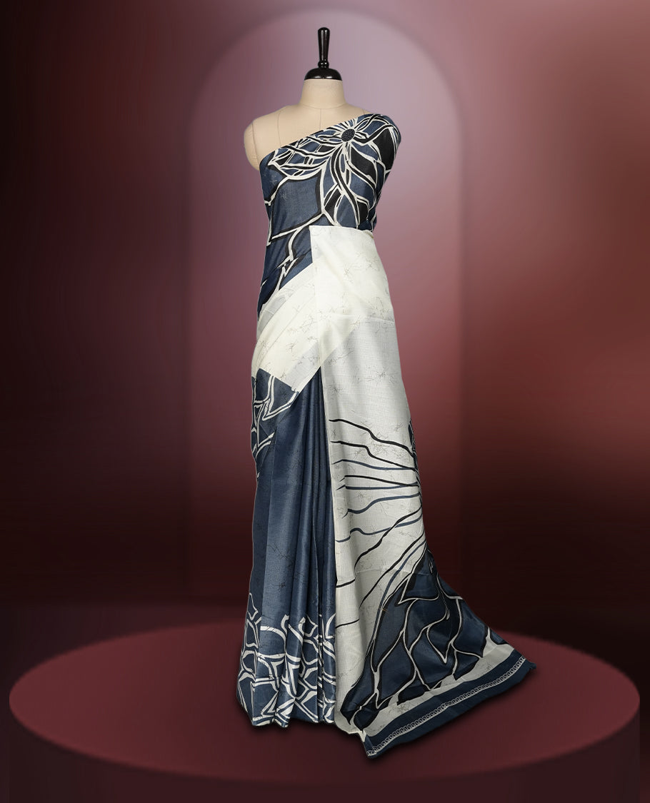 Grey and off white colour saree adorned with striking abstract floral designs, offering a perfect fusion of elegance and contemporary charm & paired with a matching blouse.