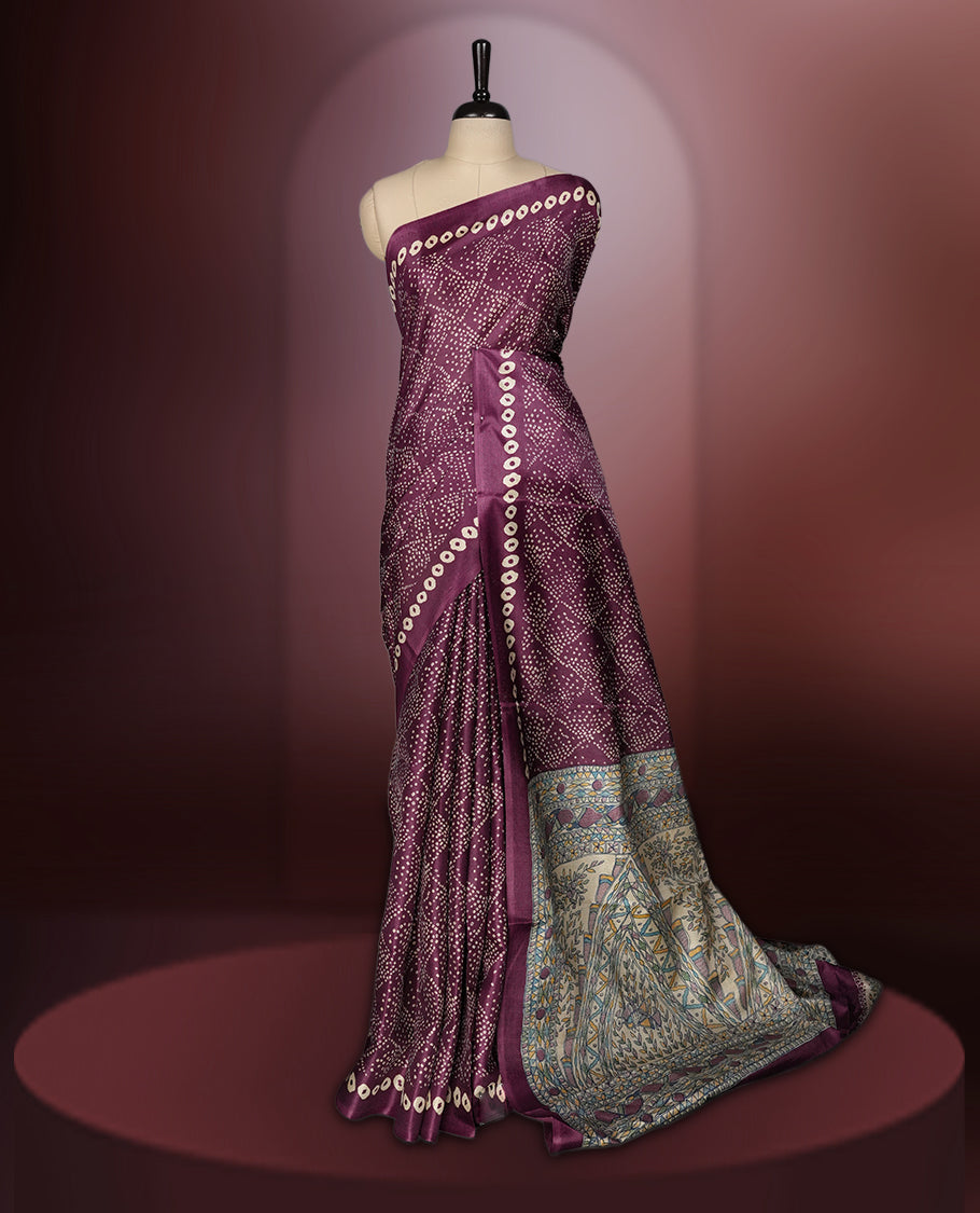 Dark grape colour saree adorned with intricate beige bandhani patterns and a contrasting pallu featuring exquisite beige floral motifs, perfectly paired with a matching blouse for a regal look.