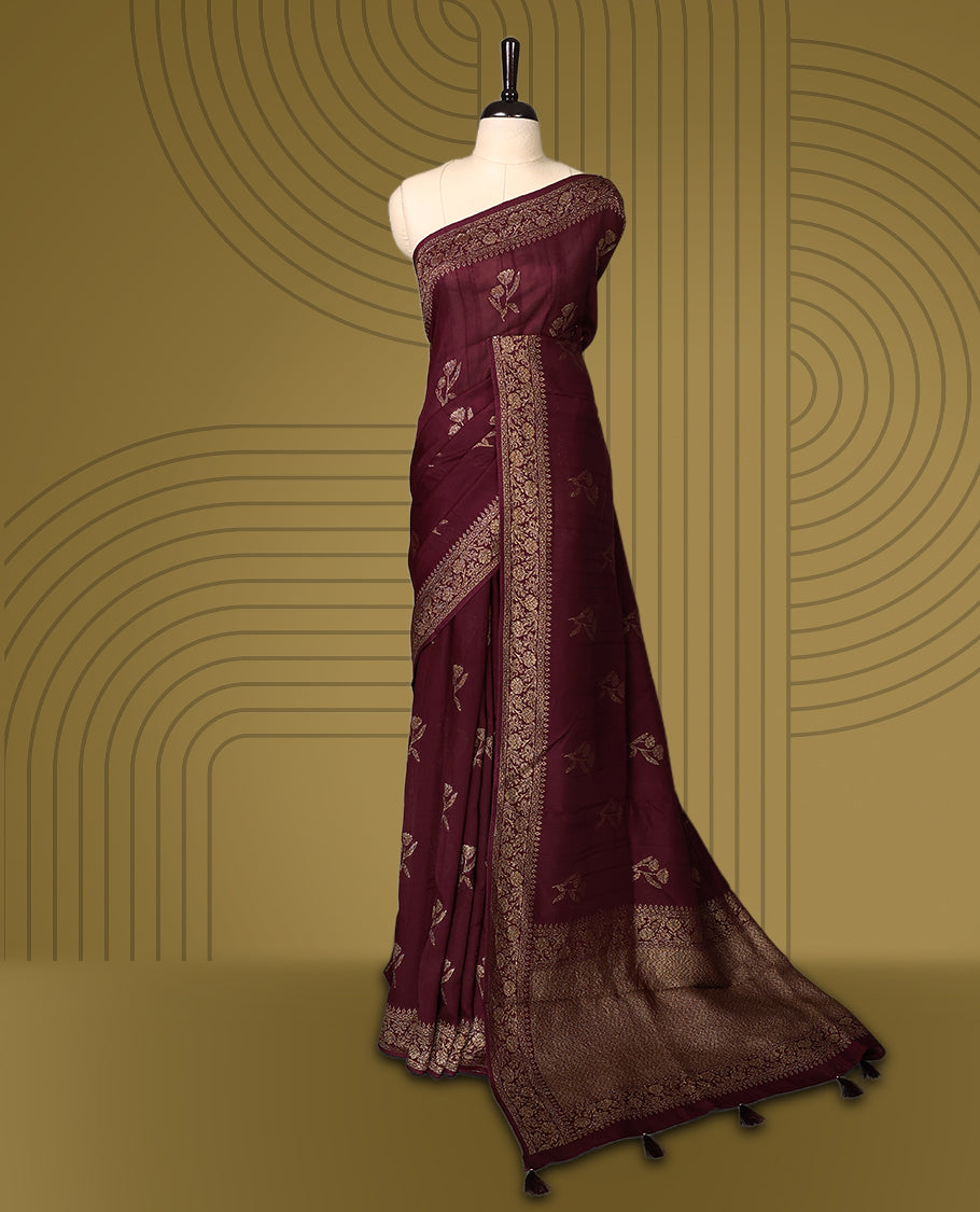Dark coffee brown colour semi Banaras tussar saree adorned with golden floral motifs along the border and scattered designs across the body, finished with a rich golden zari pallu, paired with a matching blouse.