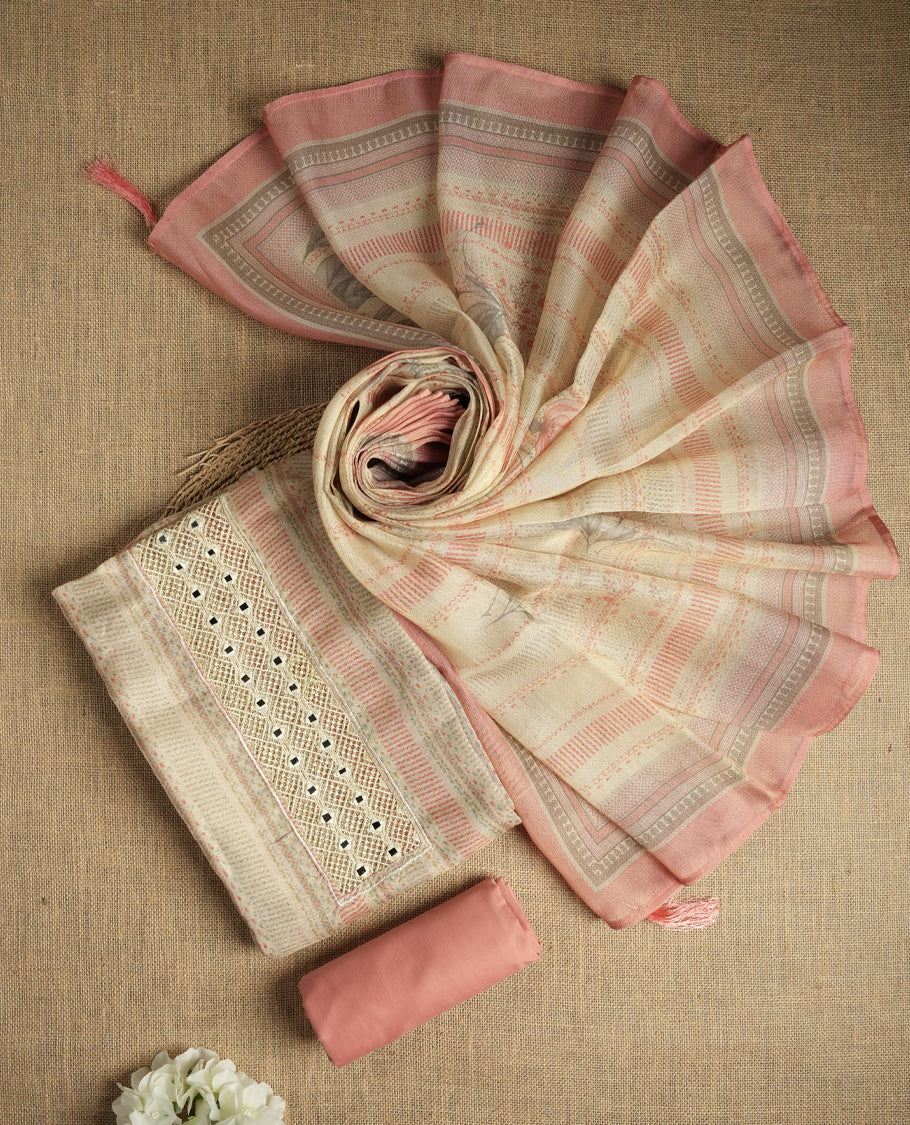 Pastel peach and beige colour suit material with delicate woven mirror work patterns and subtle zari detailing & Includes a soft dupatta with a floral touch and plain matching bottom.