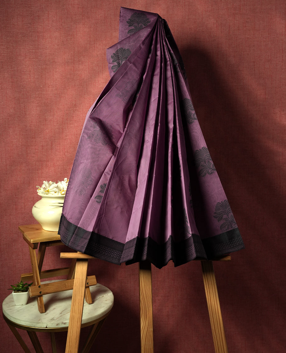 Pastel purple colour silk cotton saree featuring elegant floral zari motifs on the body, complemented by a rich contrast dark border and pallu with traditional woven detailing & Comes with a matching blouse piece.