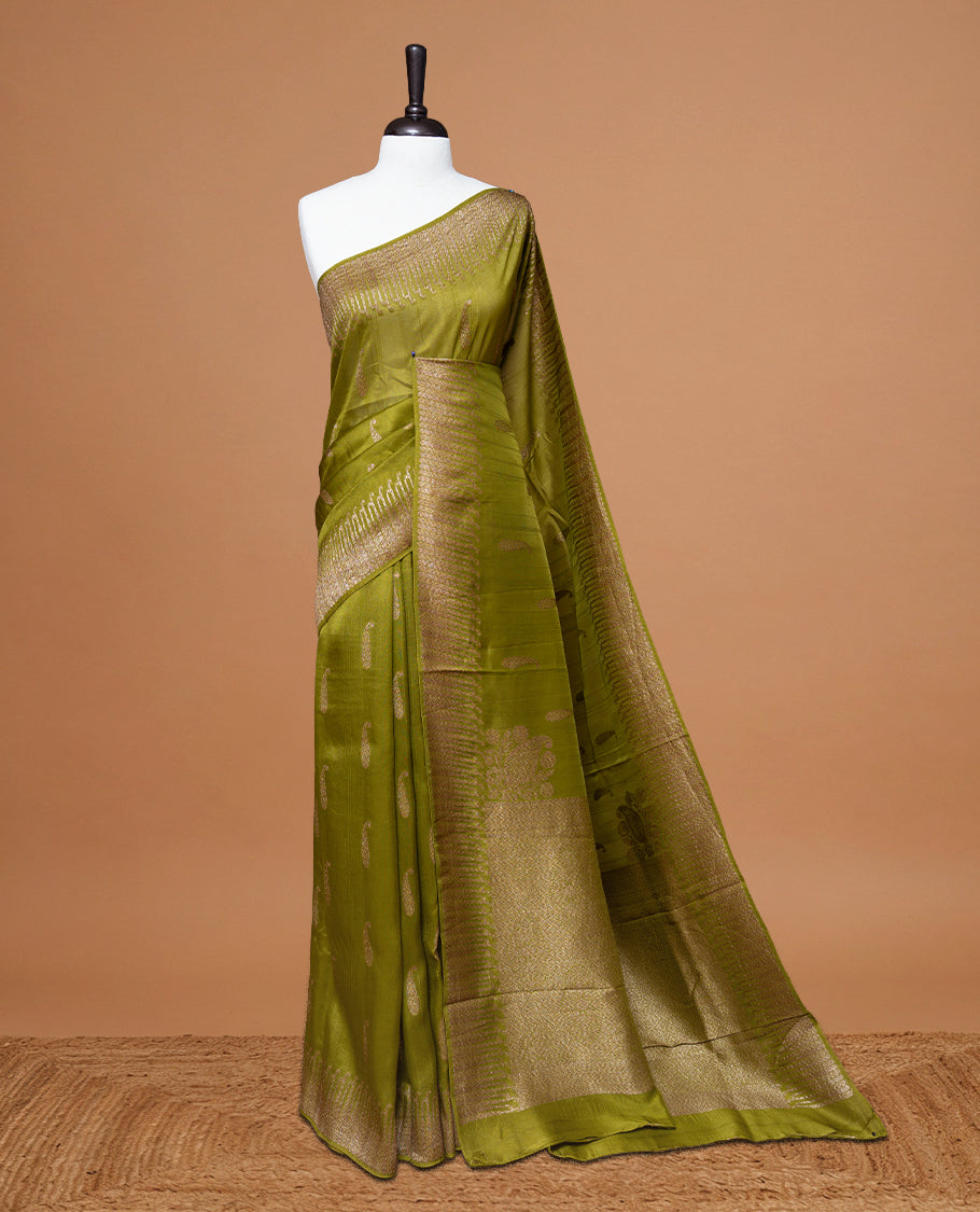 Olive colour Semi Banaras Tussar Georgette Featuring Gold zari Leaf pattern on body, Finished with Gold zari border and paired with matching blouse piece.