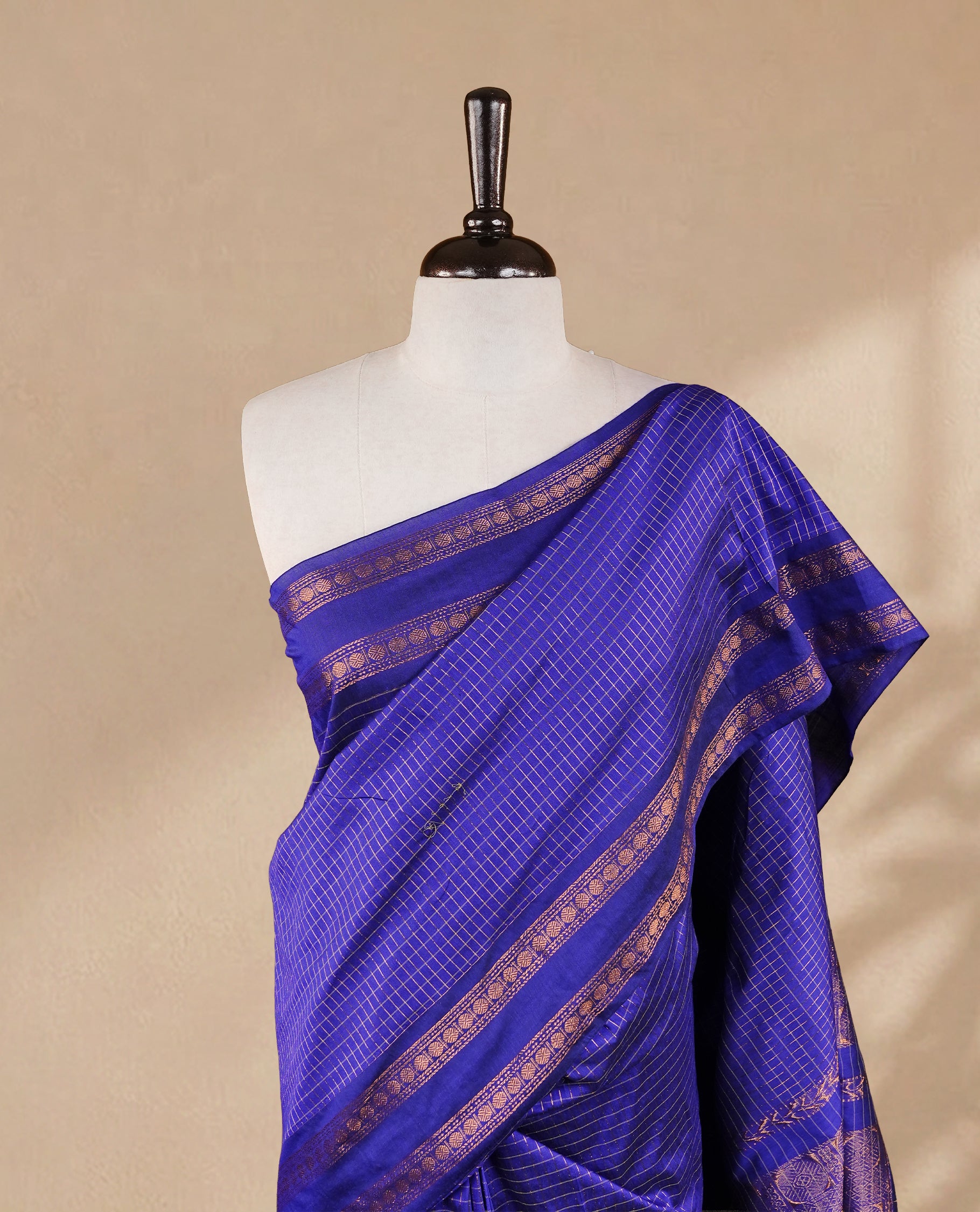 Navy blue colour kalyani cotton saree featuring gold zari strip pattern on body, complemented by self colour with Antique zari border, paired with matching blouse piece.
