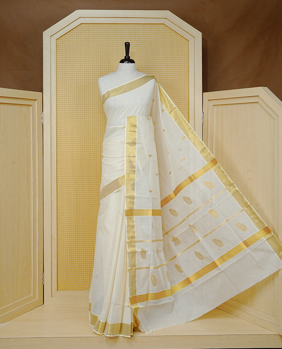 Cream Colour Cotton Kerala Saree Featuring Delicate Gold Zari Leaf Pattern Across The Body, Enhanced With A Traditional Gold Zari Border , A Gold Leaf Motifs Striped Gold Zari Pallu, Finished With A Matching Blouse Piece