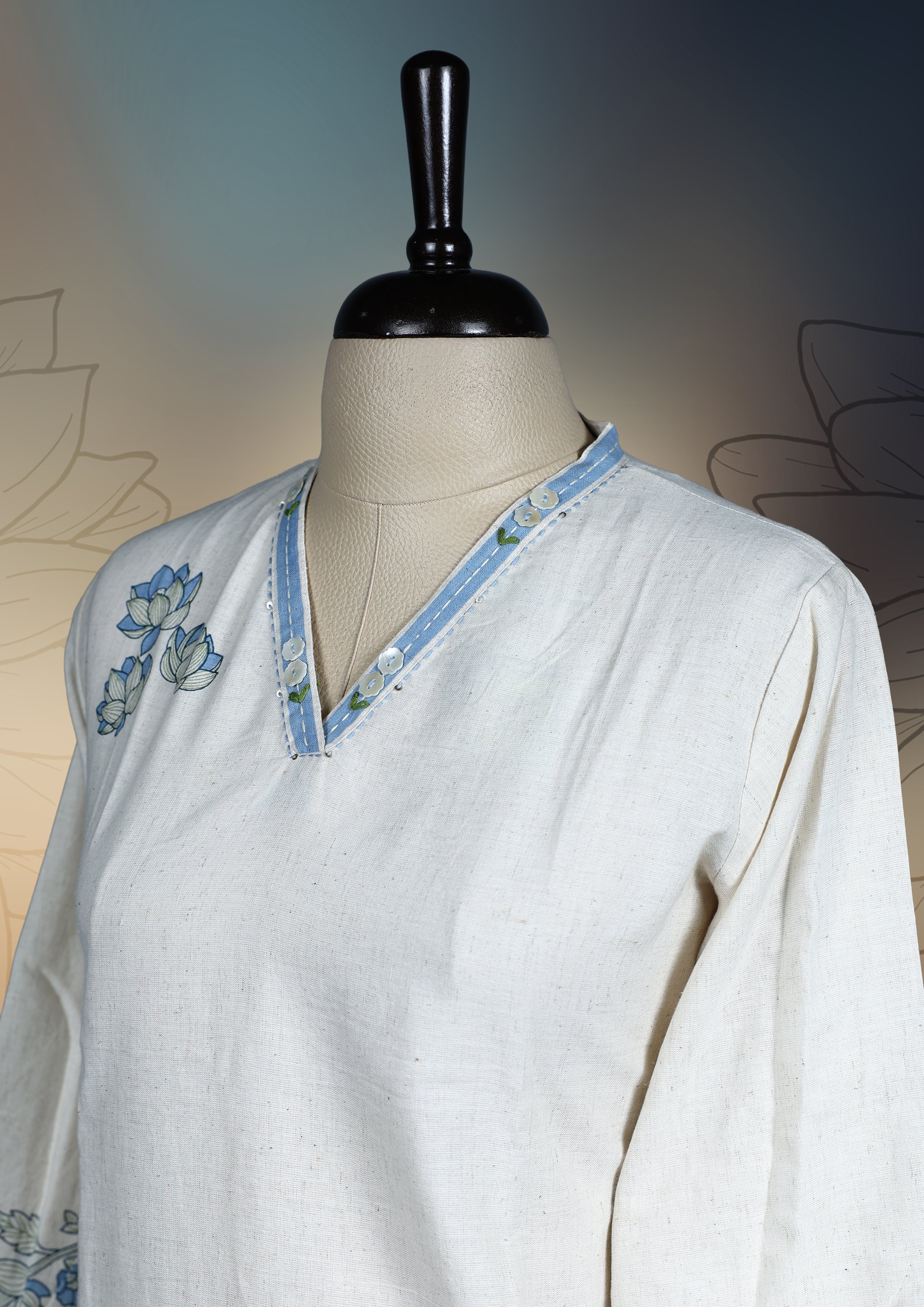 Off white colour kurthi with soft blue and pastel green floral embroidery on the neckline, sleeves, and hem & Featuring a classy V neck and three quarter sleeves, perfect for a refined and comfortable everyday look.