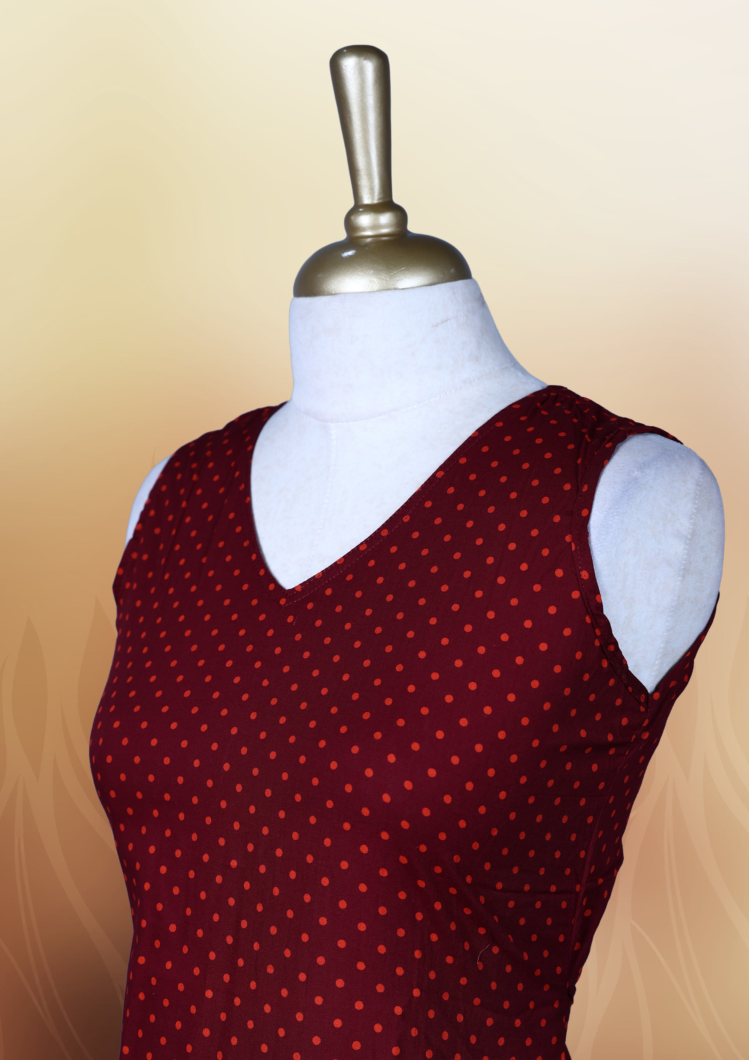 Dark maroon colour nightwear with orange colour polka dots, V neckline, and flutter sleeves & The flared hem with pleats adds a chic touch, Ideal for casual wear, office looks, or relaxed outings with a stylish twist.