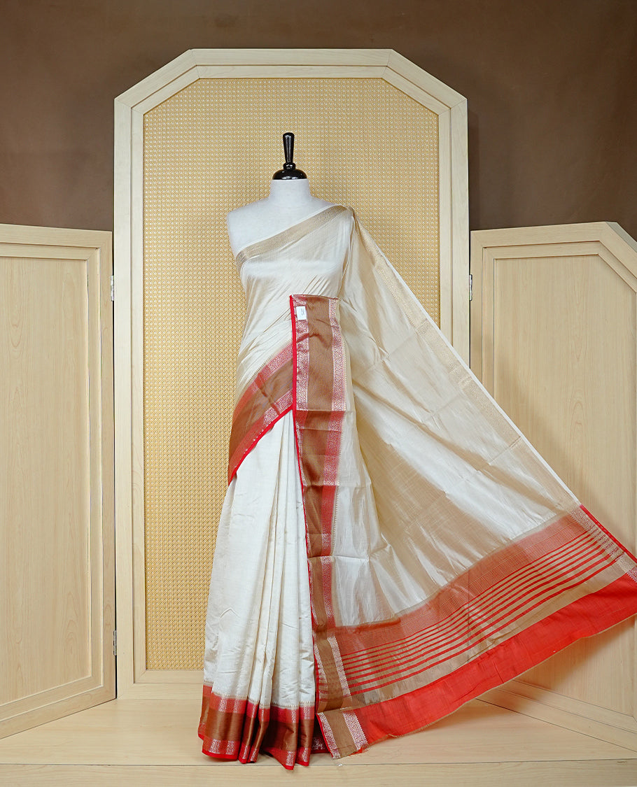 Cream colour semi Tussar silk saree featuring Elegant body, Complemented by contrast Red with rich zari detailed for onam special, paired with contrast Blouse for Festive look.