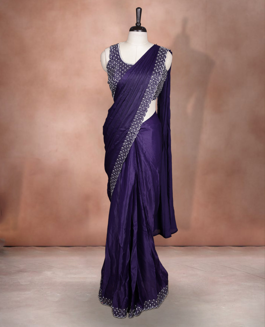 Elegant deep purple colour ready to wear saree adorned with rich white stone and bead embroidery along the border and pallu, paired with a heavily embellished matching blouse for a grand festive look.