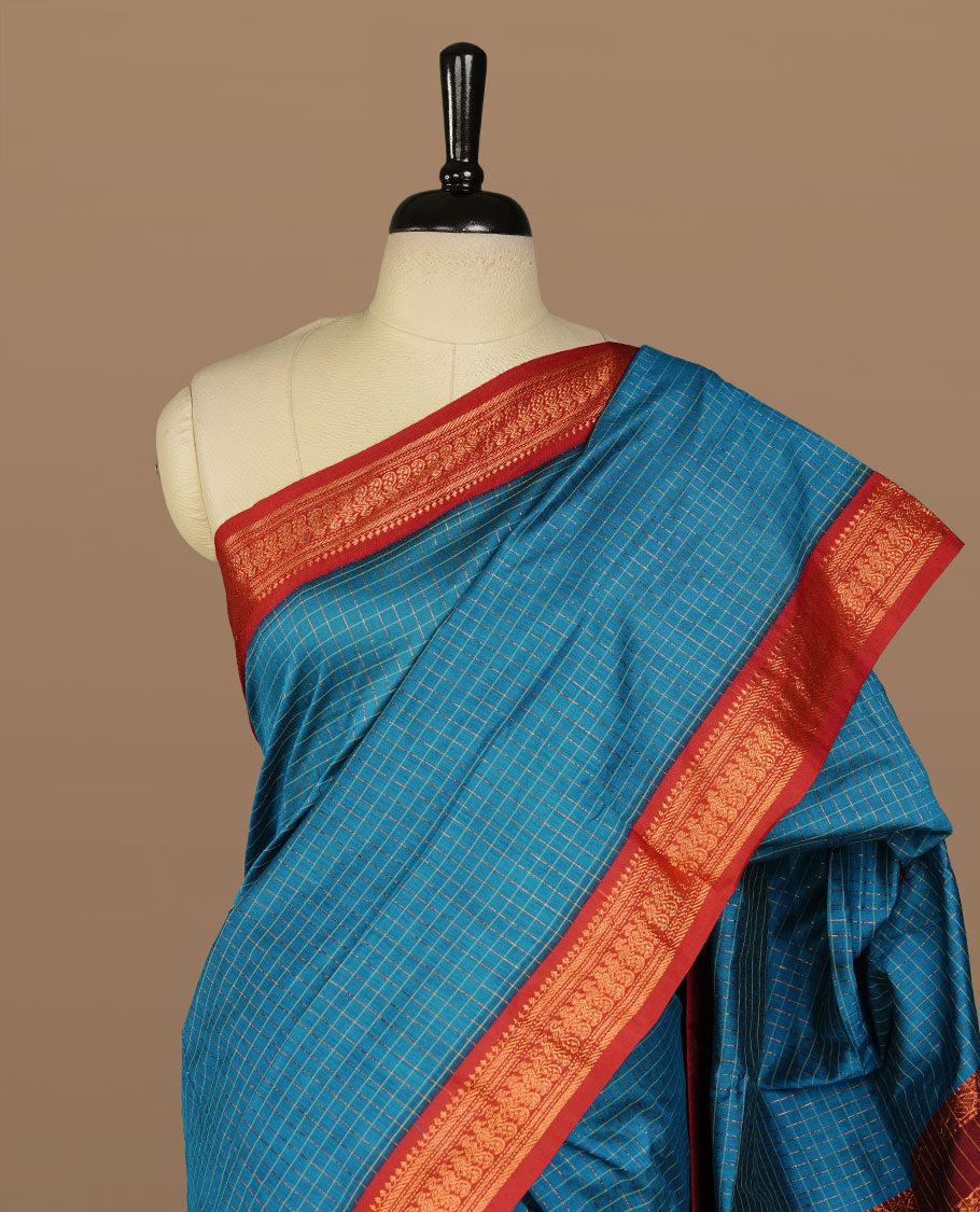 Blue colour kalyani cotton saree featuring gold zari check pattern on body, complemented by Maroon colour with Antique zari border, paired with matching blouse piece.