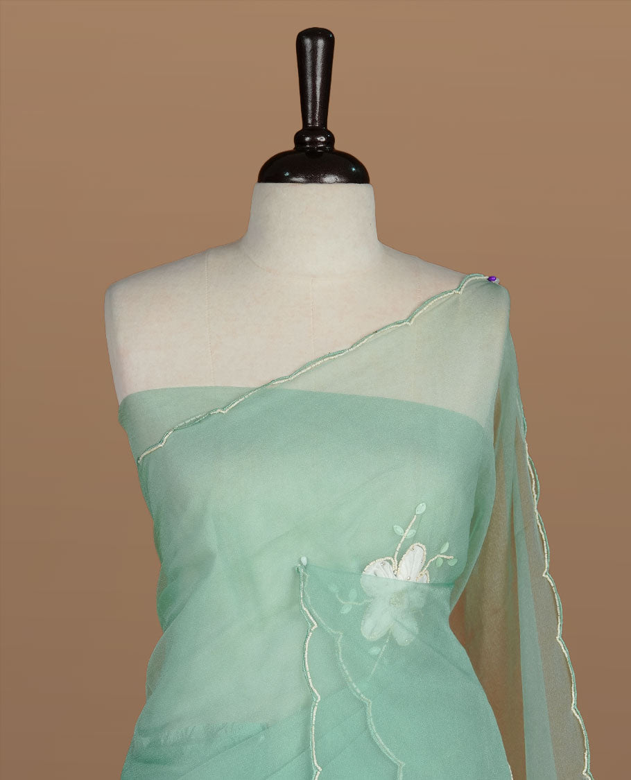 Aqua colour crush organza saree featuring white floral work with beats & sequins, highlighting scalp with beats worked border, paired with matching blouse piece.