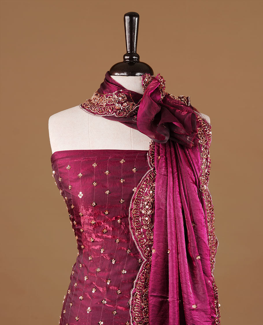 Burgundy colour churidhar material featuring cut beads and sequins work on the body, paired with a matching unstitched bottom and worked dupatta.
