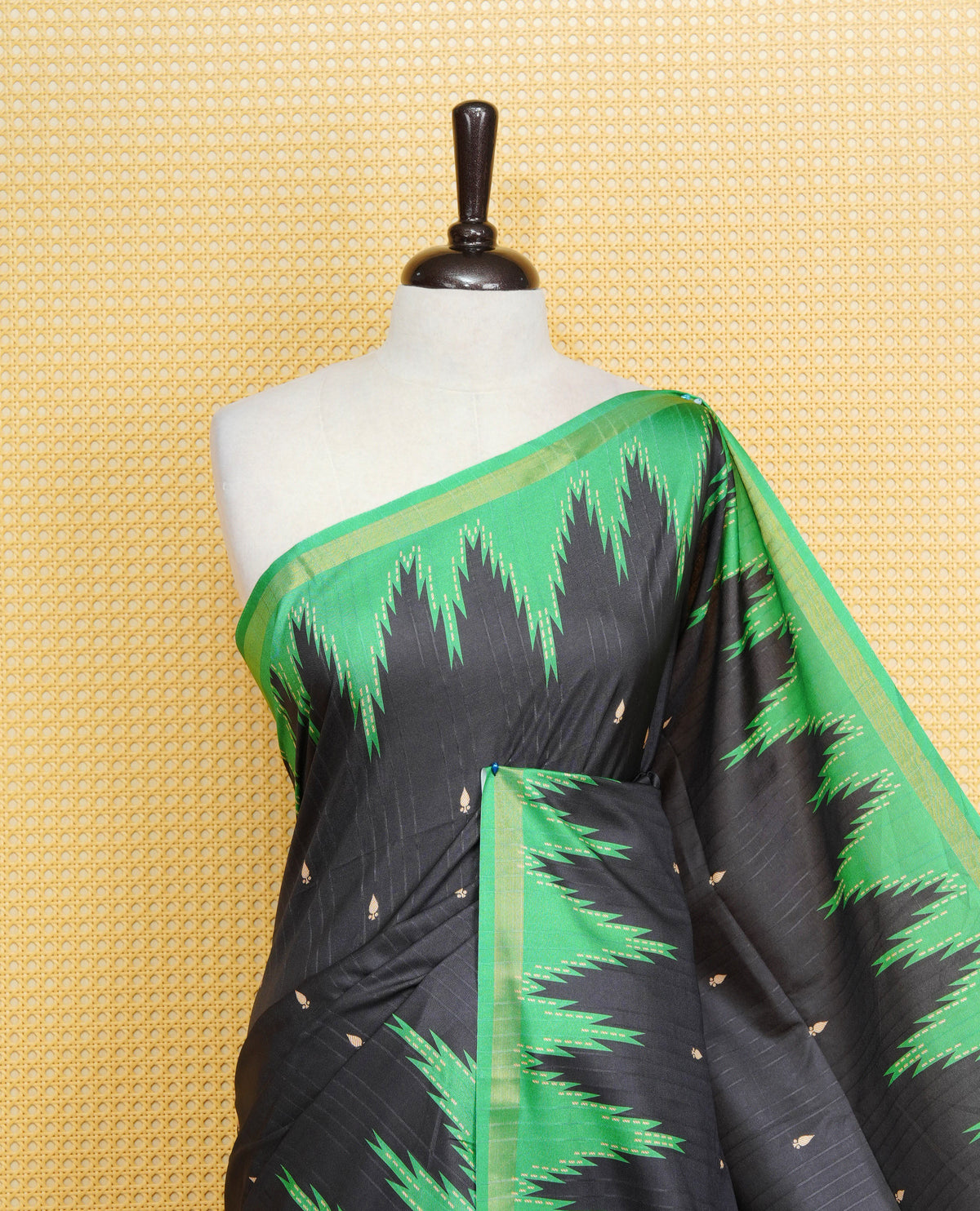 Black And Green Colour Kattan silk saree featuring buttas all over the body, a temple-designed border & a contrasting striped pallu with tassels. Paired with a matching contrast-striped blouse piece.