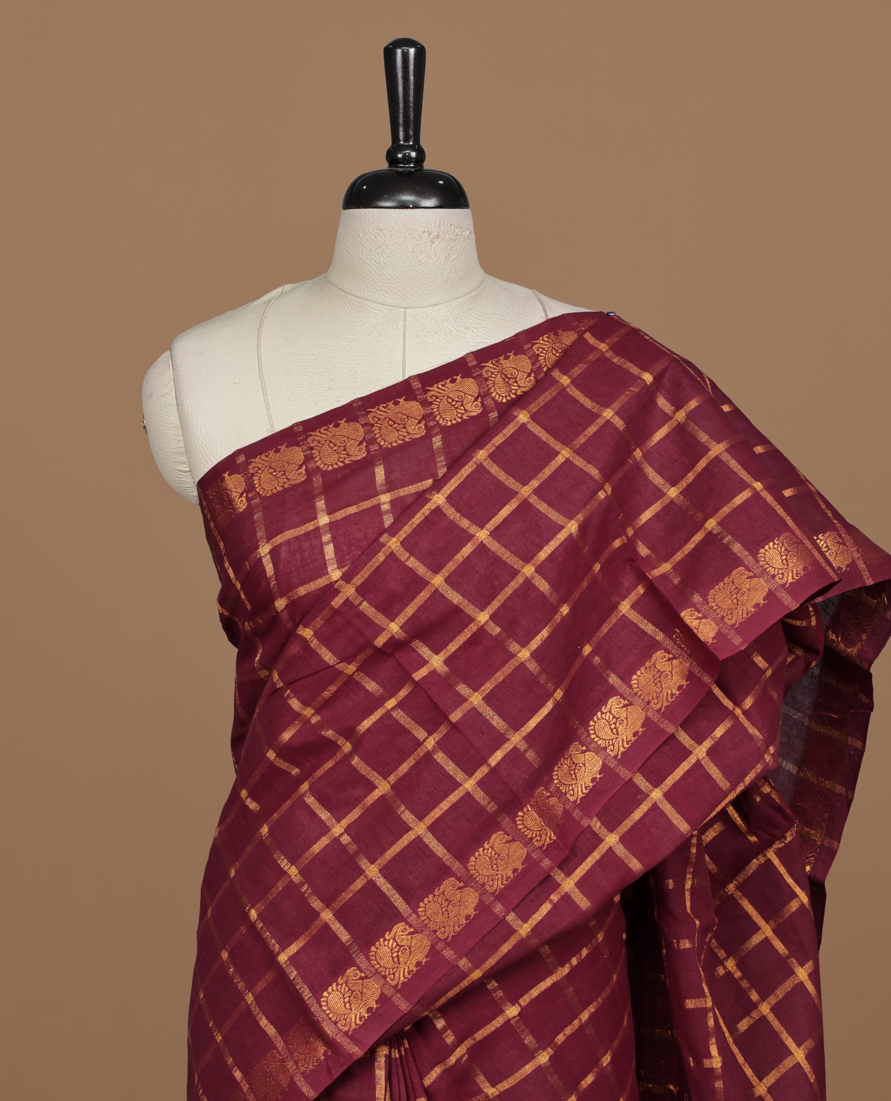 Maroon colour Sungudi cotton saree featuring Gold zari Check pattern on body, Gold zari Peacock design on Self colour border, paired with matching blouse piece.