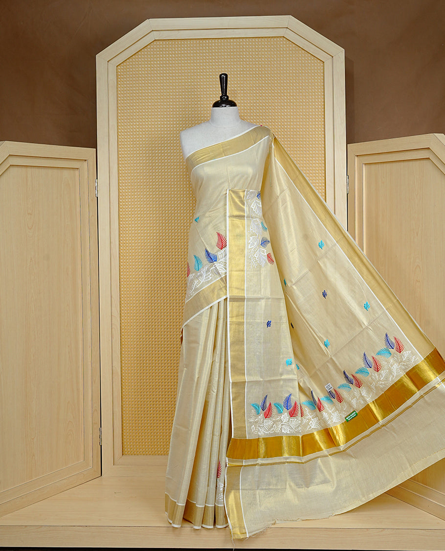 Cream colour Tissue kerala saree featuring Embroidery buttas on body, complemented by Leaf thread work & kasavu kara, comes with matching blouse piece.