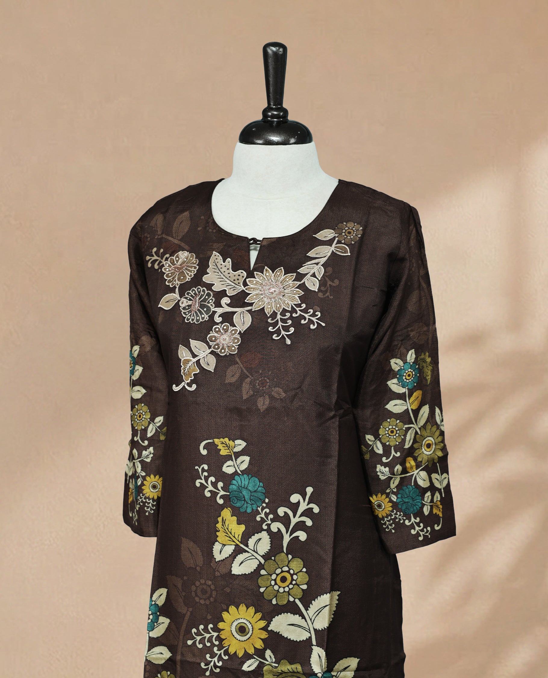 Brown Kurti featuring digital floral prints across the body, a U-shaped neckline adorned with stone and threadwork, and a 3/4-sleeve design.