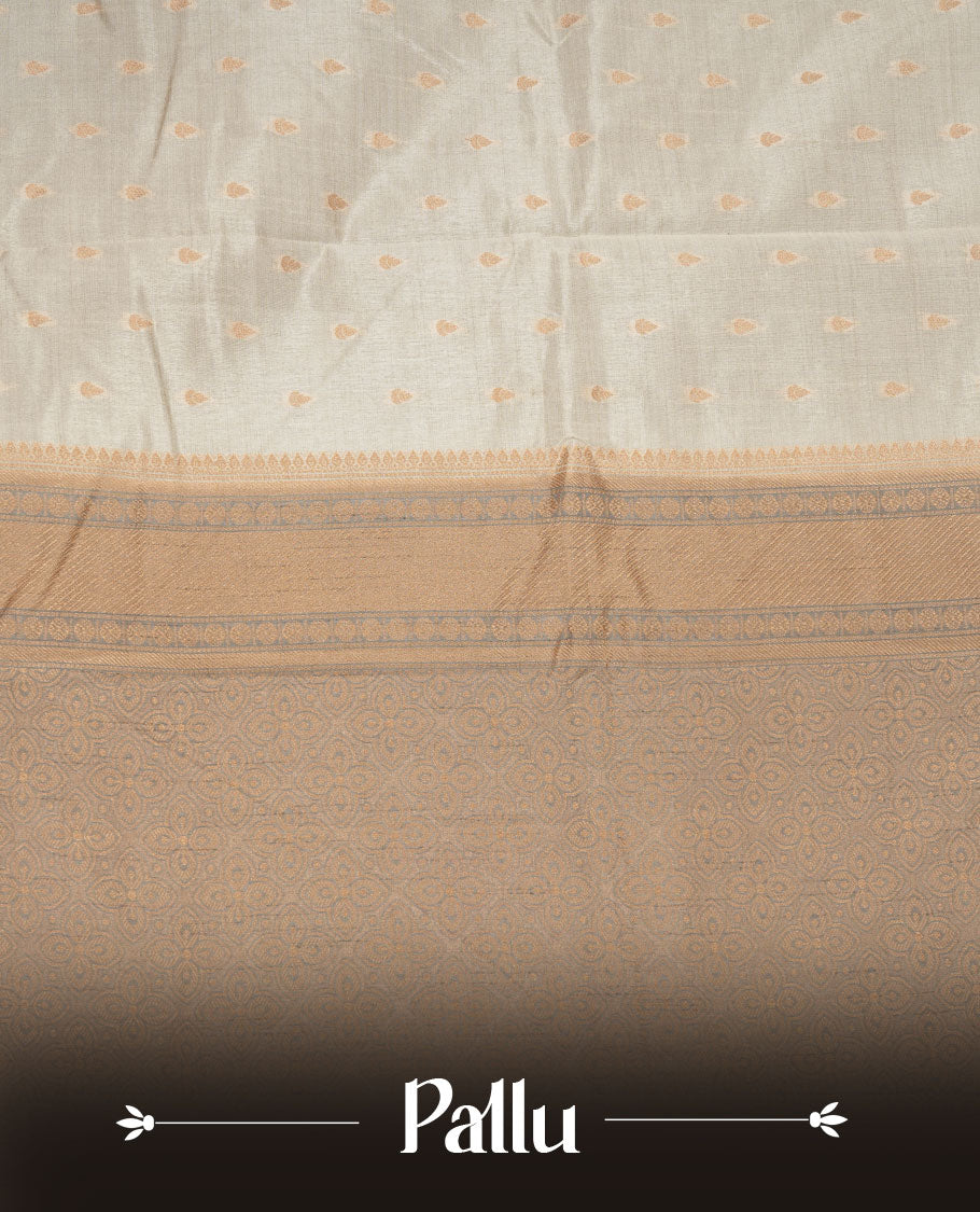 Cream colour tussar saree featuring litte gold zari motifs on body, contrast grey colour border and pallu with zari woven design, comes with matching blouse piece.
