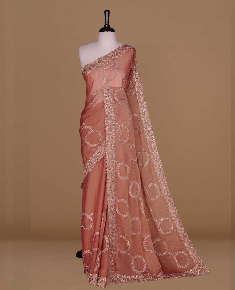 Pinkish orange colour organza saree featuring thread & gold stone pattern on body, highlighting scalp border, paired with Matching blouse piece.
