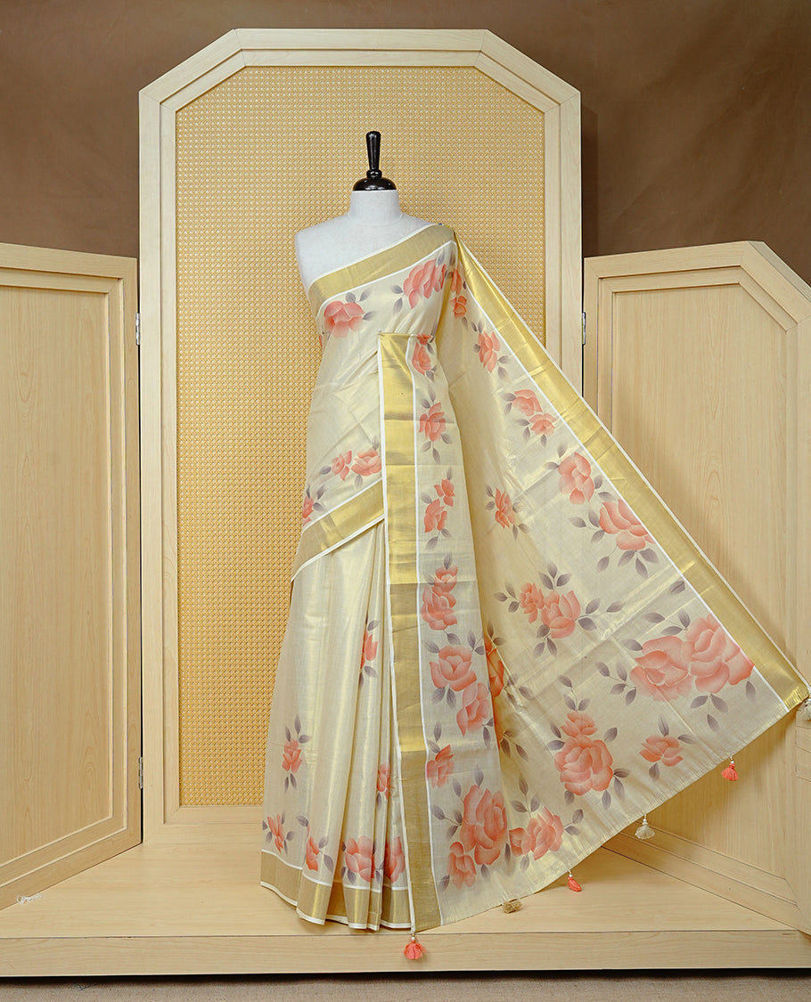 Cream Colour Tissue Kerala Saree Featuring Digital Peach Rose Prints Across The Body, Enhanced With A Gold Zari Border , Finished With Peach & White Tassels And A Matching Blouse Piece