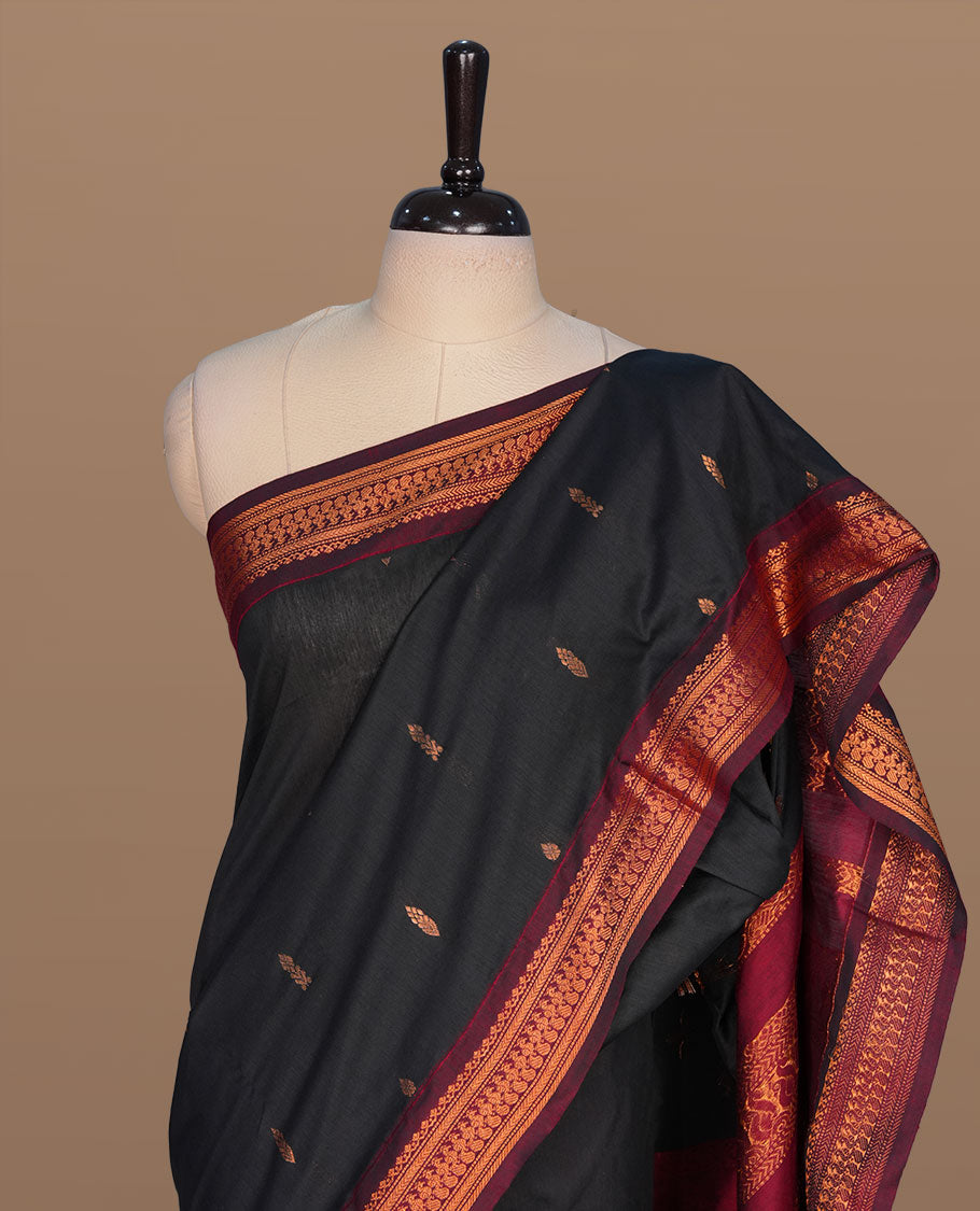 Black colour kalyani cotton saree featuring gold zari motifs on body, complemented by contrast maroon color with copper zari pattern border , paired with matching blouse piece.