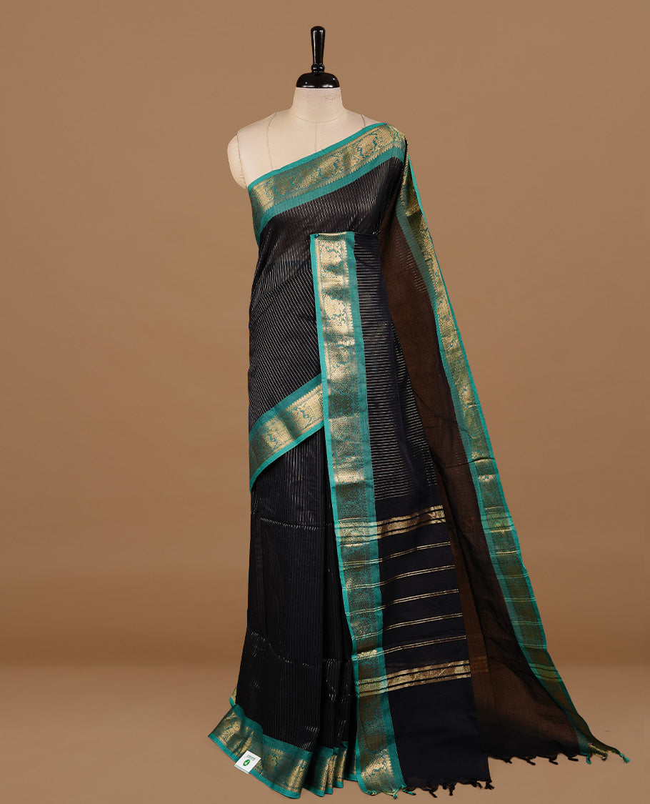 Black colour chettinad cotton saree featuring gold zari stripes on body, complemented by Green colour with zari border, paired with matching blouse piece.
