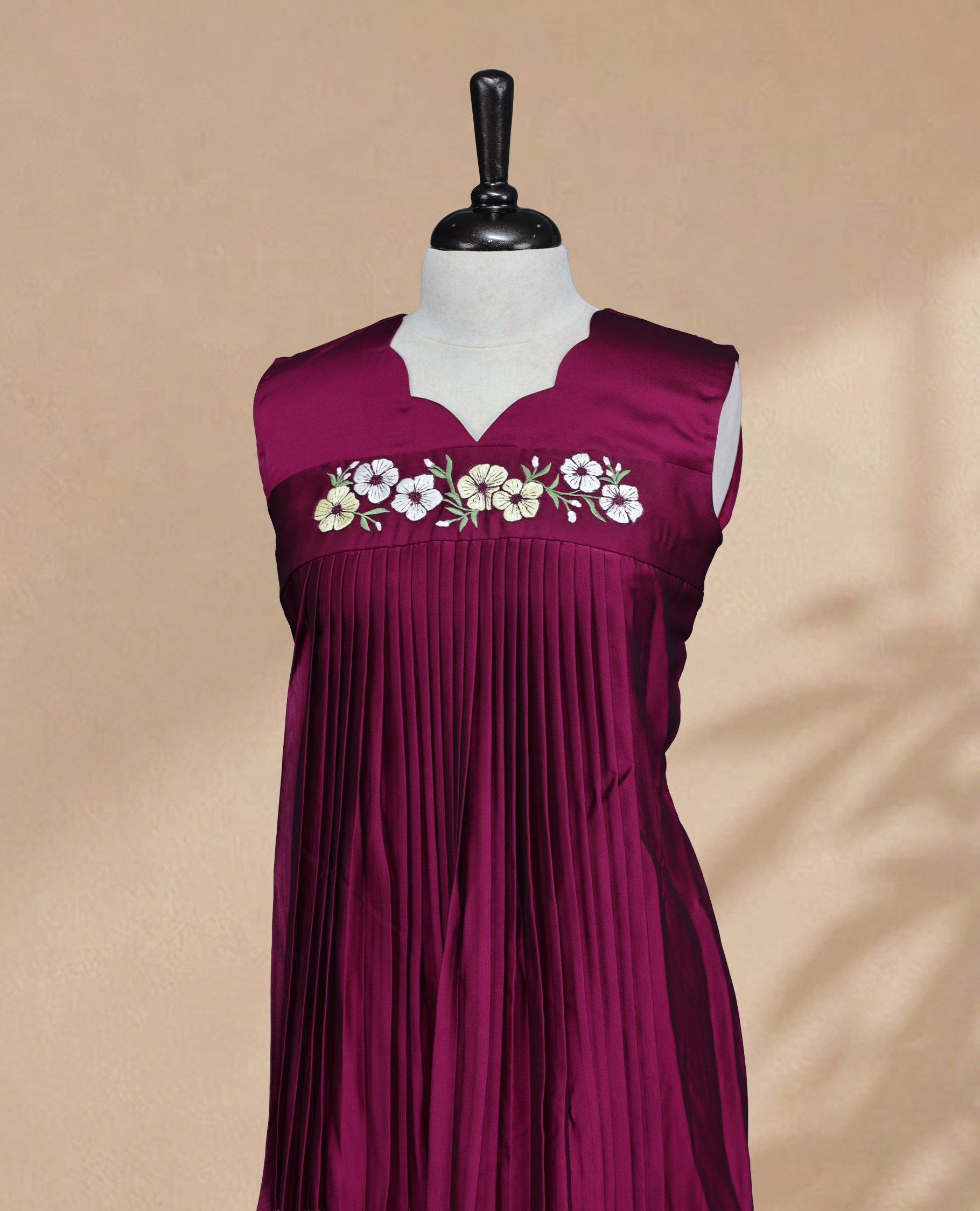 Wine Coloured Sleeveless Kurti Featuring a Designed Neckline, Floral Embroidery on the Body