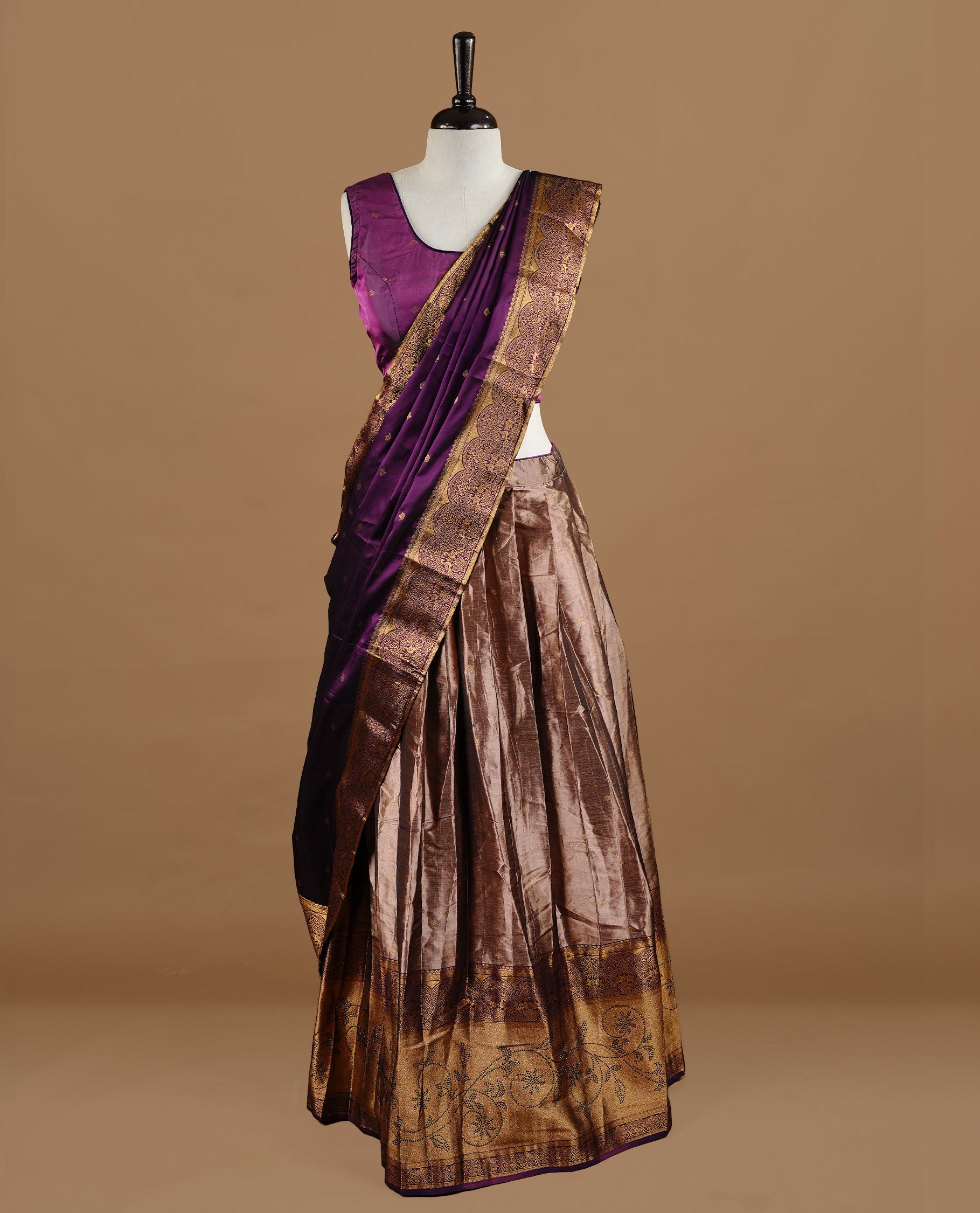 Purple colour Half saree featuring Purple colour skirt with contrast gold colour border with stone work, paired with contrast antique colour stitched blouse piece, with matching dupatta.