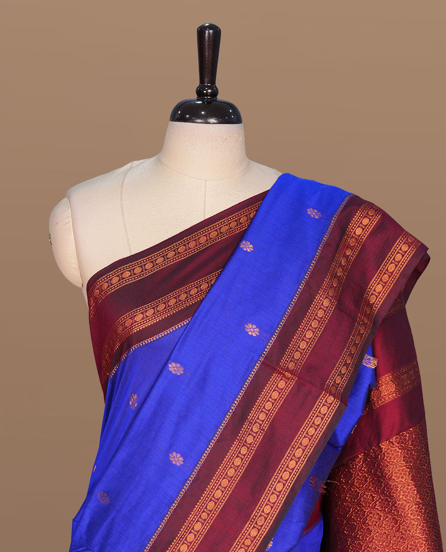 Navy blue colour kalyani cotton saree featuring gold zari motifs on body, complemented by contrast maroon color with copper zari pattern border , paired with matching blouse piece.