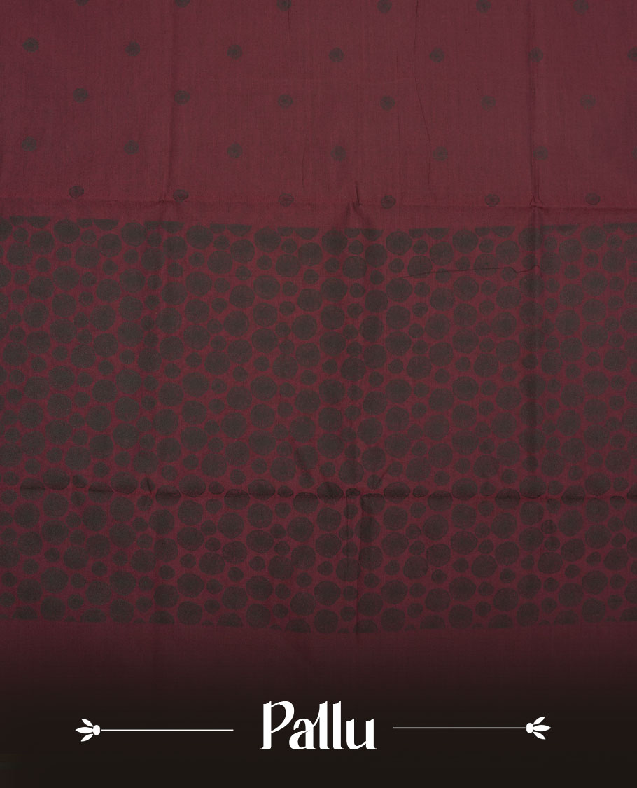 Dark maroon colour poly cotton saree with black abstract butti motifs on the body, paired with a matching pallu with dense black textured round butta pattern, and a coordinated all‑over textured round butta printed blouse piece.