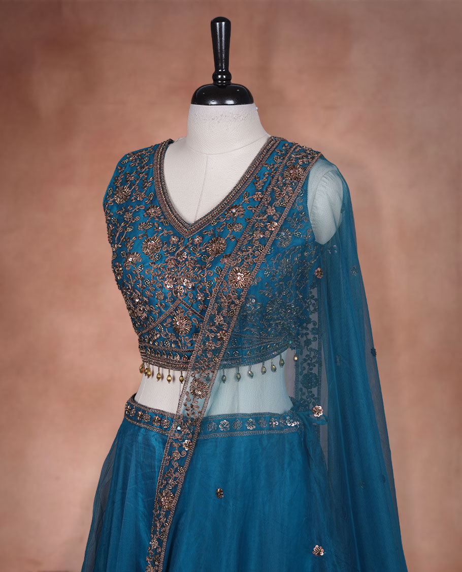 Dark blue colour lehenga set with stitched sleeveless Antique thread embroidered & beats worked blouse featuring sheer neckline, matching stitched flared lehenga, and plain sheer dupatta.