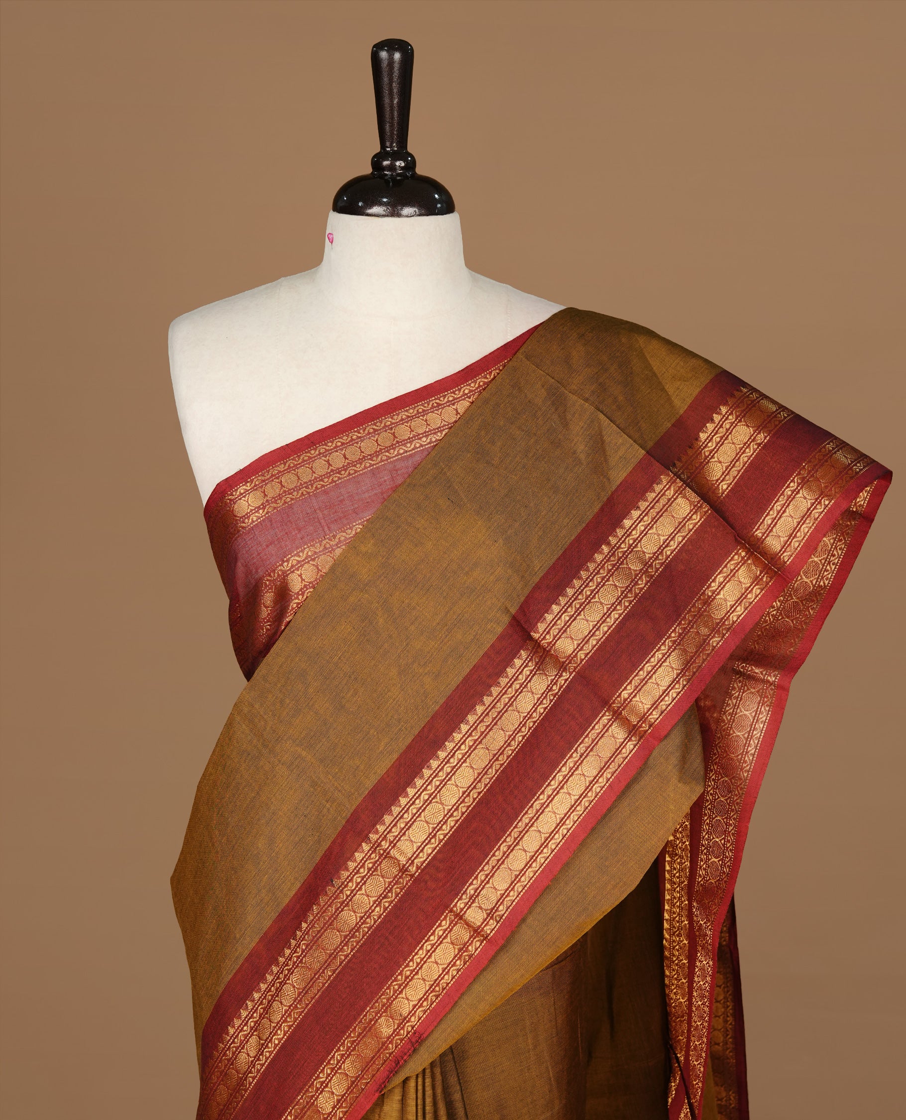 Dark olive colour Chettinad cotton saree featuring Elegant plain body, complemented by contrast Maroon colour with gold zari border, paired with matching blouse piece.