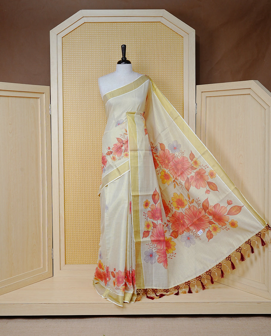 Cream Colour Tissue Kerala Saree Featuring A Digital Floral Printed Body & Pallu, , Beautifully Enhanced With A Classic Gold Zari Border And Cream & Brown Tassels ,Paired With A Matching Blouse Piece.