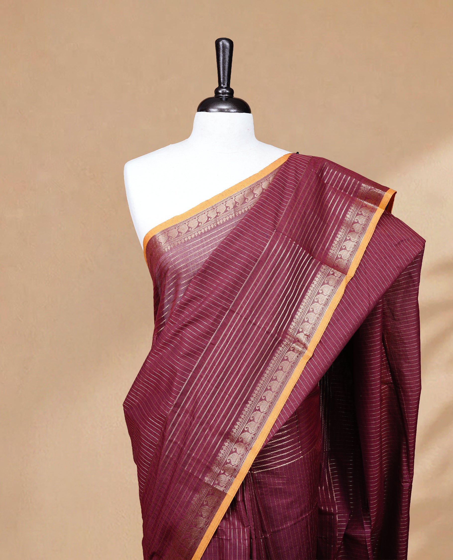 Maroon colour Chettinad cotton saree featuring Gold zari stripes on body, complemented by Self colour with Gold zari border mustard piping, paired with matching blouse piece.