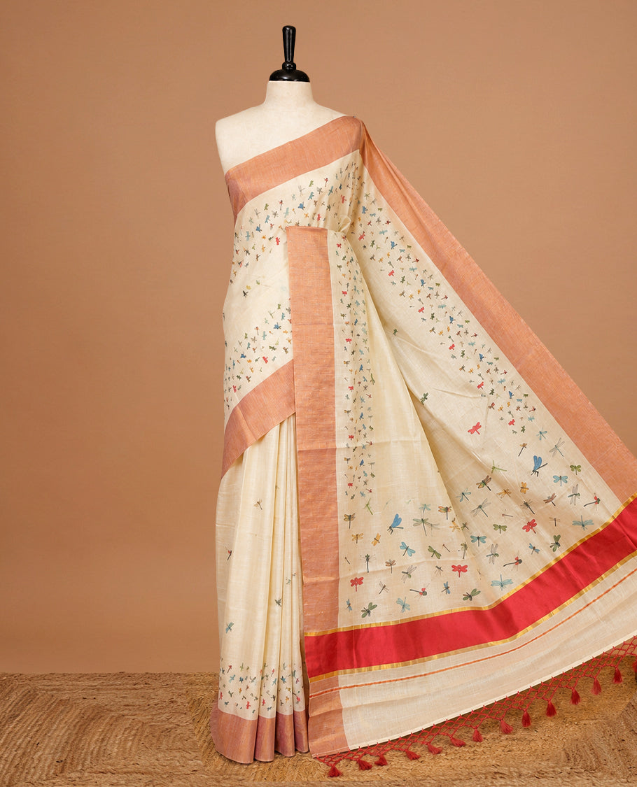 Cream Colour Kerala Saree Featuring Plain Body ,Complemented By A Red Zari With Dragonfly Printed Border ,Enhance By A Red With Gold Zari Pallu ,Paired With A Matching Blouse Piece.