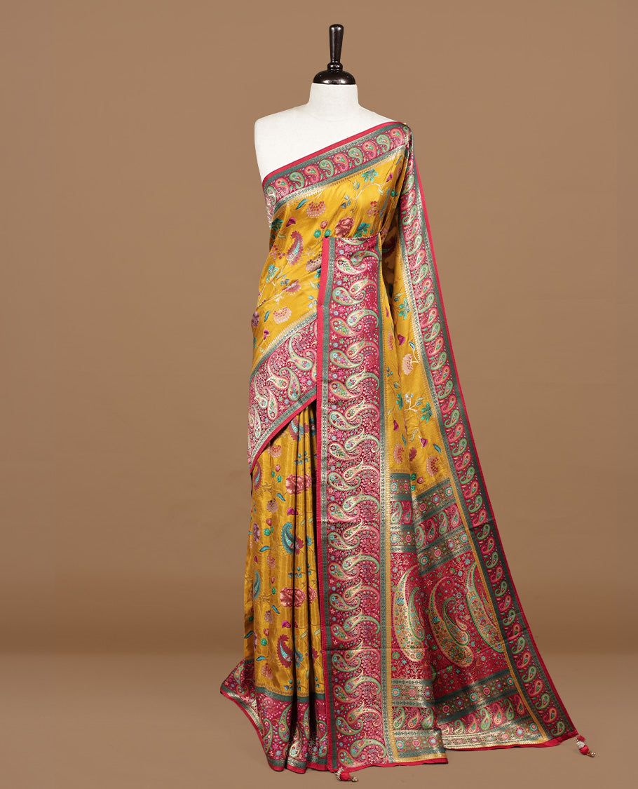 Mustard yellow colour Pashmina silk saree features an all over floral body, a contrast crimson red paisley border and pallu, and a matching unstitched blouse.