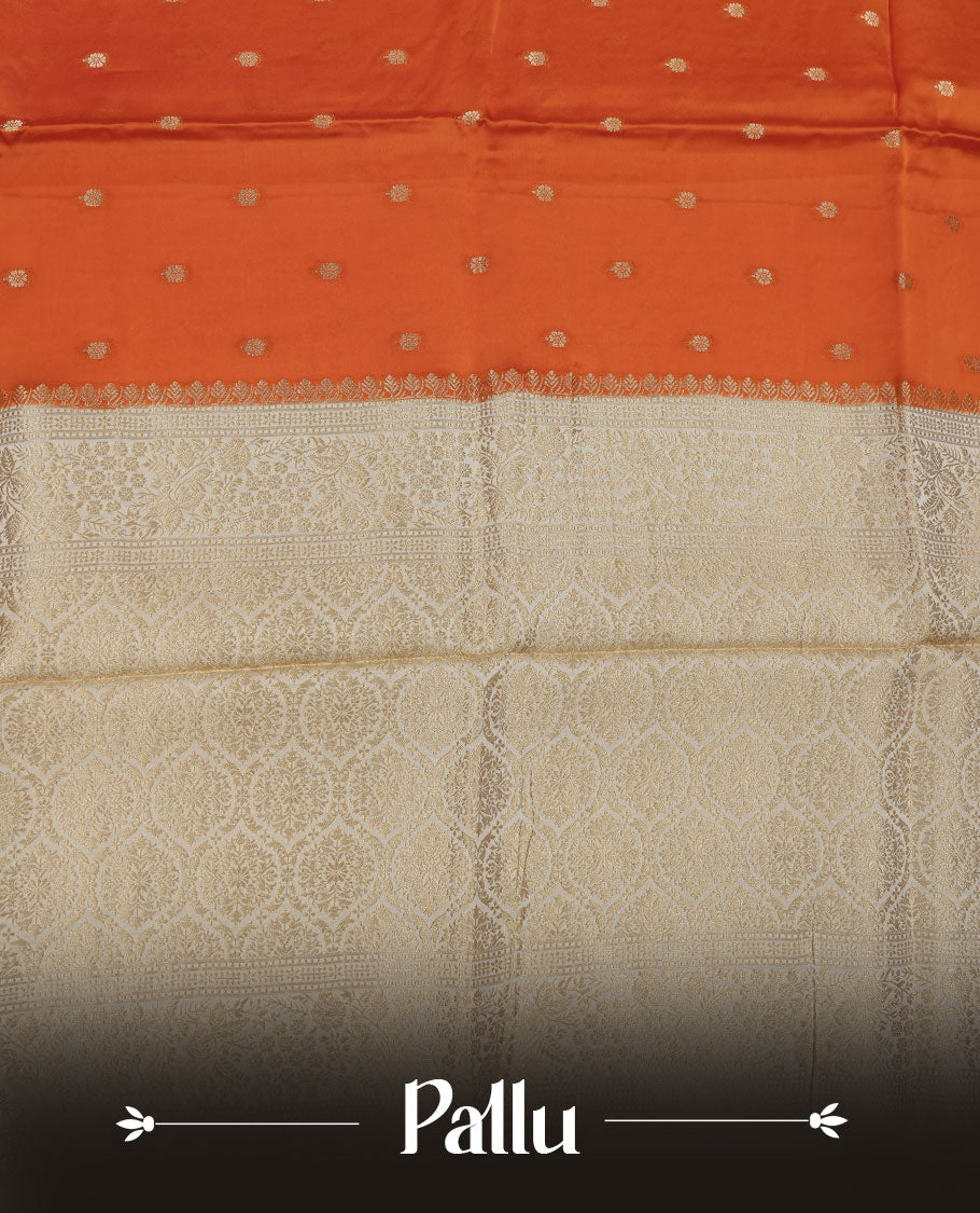 Orange colour banaras satin crepe saree featuring gold zari motifs on body, with contrast cream colour border with gold zari pattern and paired with matching blouse.