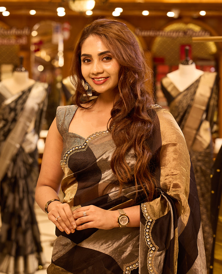 Antique gold and black pure Banaras tissue organza designer saree featuring a vertical black tissue pallu and shoulder panel, a plain antique gold body, and a delicate scalloped embellished border, paired with a matching designer blouse.