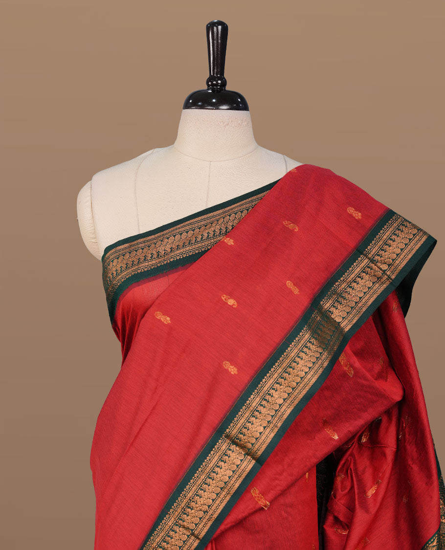 Red colour kalyani cotton saree featuring antique zari motifs on body, complemented by Green colour with Antique zari border, paired with matching blouse piece.