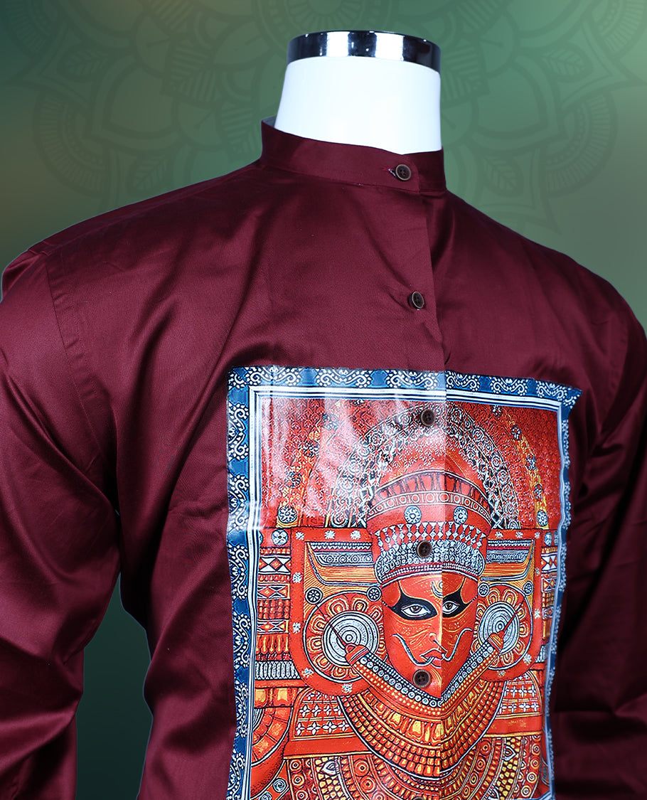 Maroon men’s shirt tailored in a smooth finish, designed with a mandarin collar, full sleeves, and highlighted with an intricate multicolour Theyyam inspired print panel on the front, perfect for festive and cultural wear.