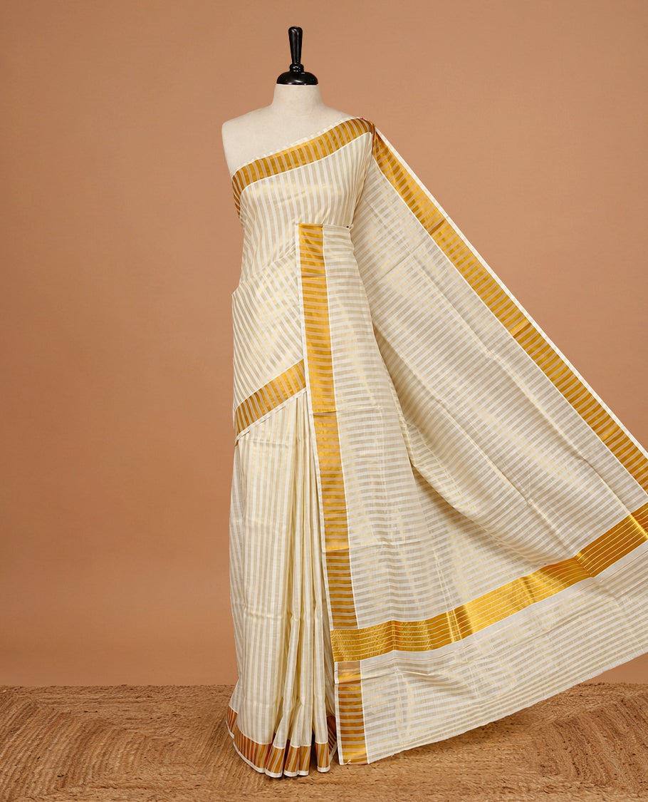 Cream colour Kerala saree featuring Gold zari Stripped body, enrich by Classy zari Border, pallu ,comes with matching blouse piece.