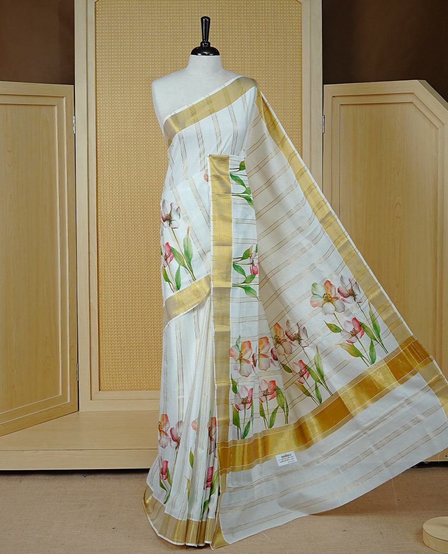 Cream Colour Kerala Saree Featuring Gold Zari Stripes On Body, Enrich Gold Zari With Floral Printed Border & Pallu, Paired With Matching Blouse Piece.