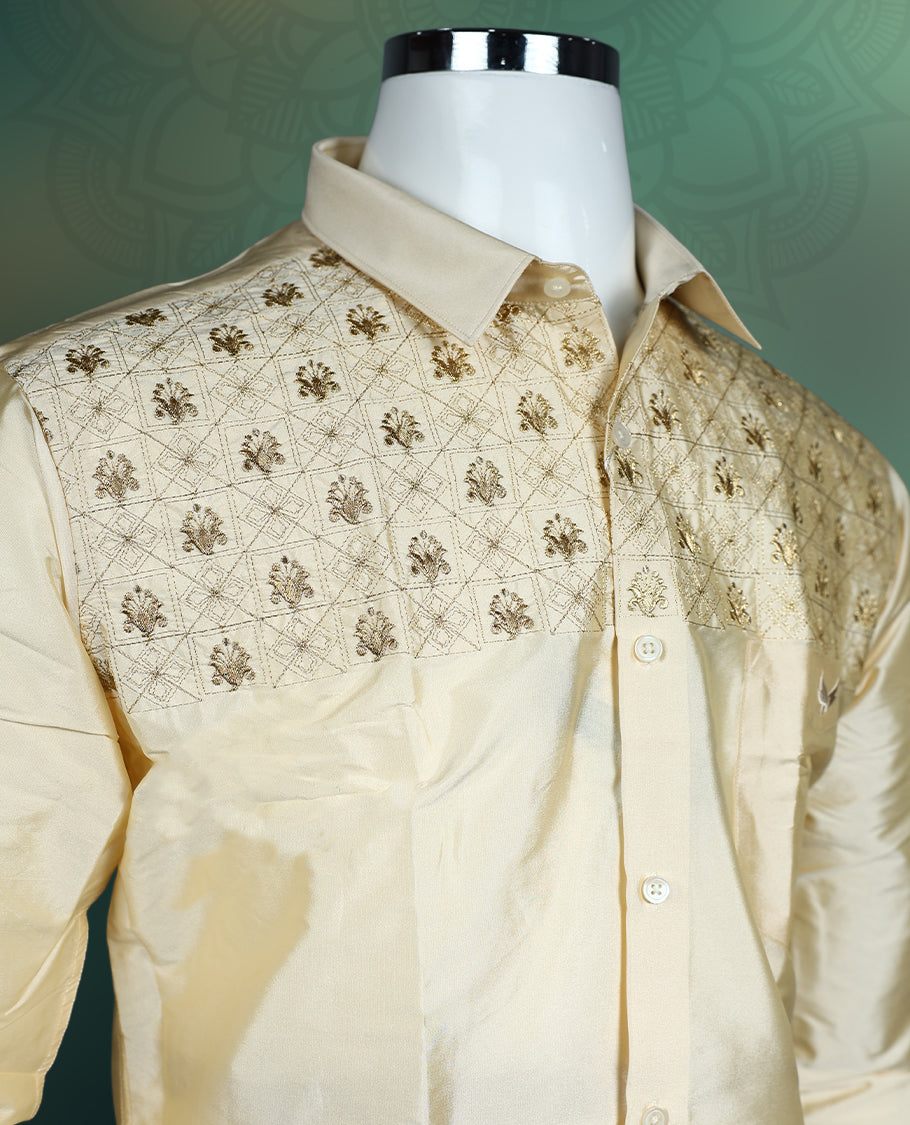 Elegant cream silk shirt featuring intricate golden thread embroidery on the yoke, styled with a classic collar, full sleeves, and buttoned front, ideal for weddings, festive, and traditional occasions.