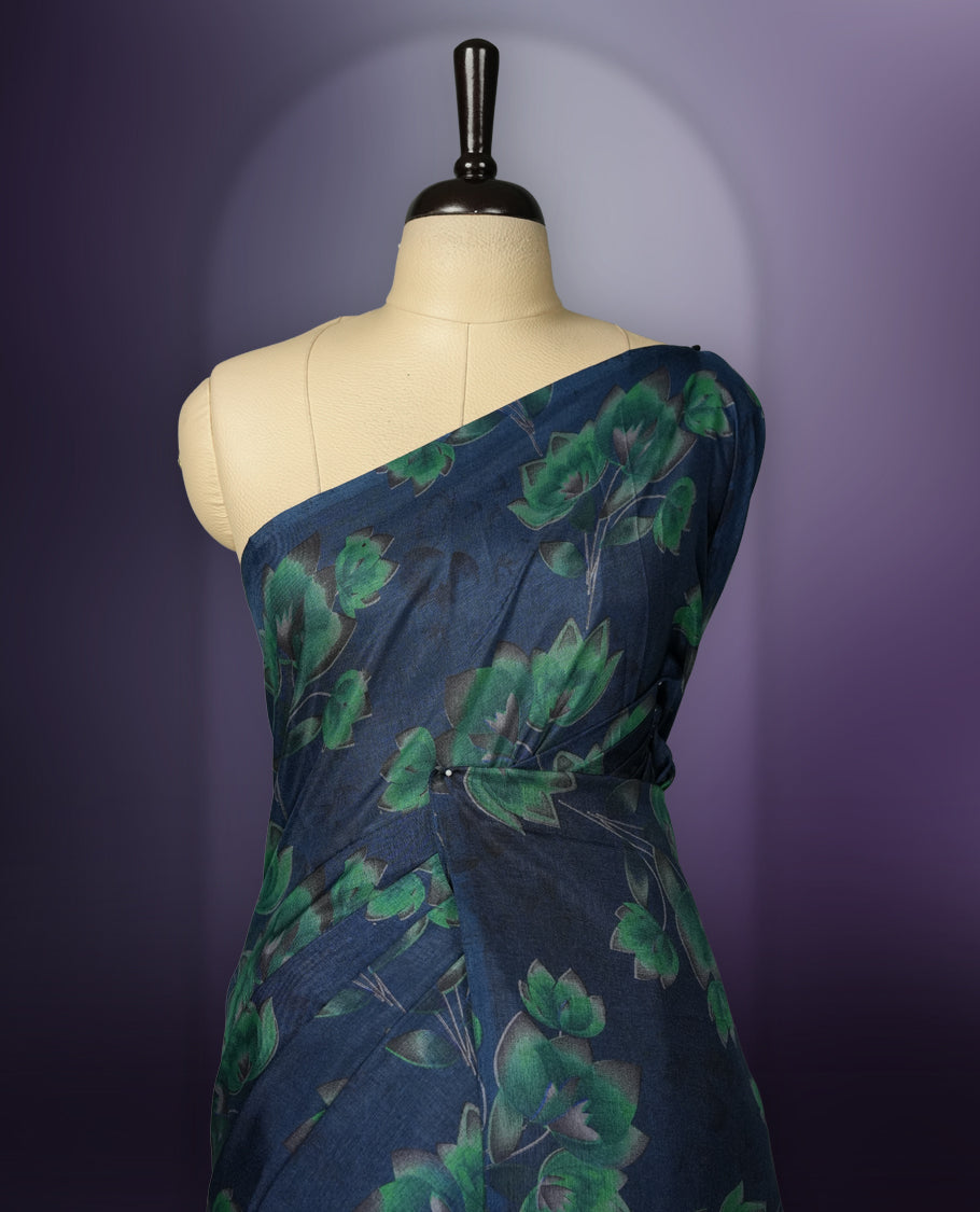 Navy Blue colour saree enhanced with a vibrant green colour floral prints on body & pallu, and comes with a matching blouse.