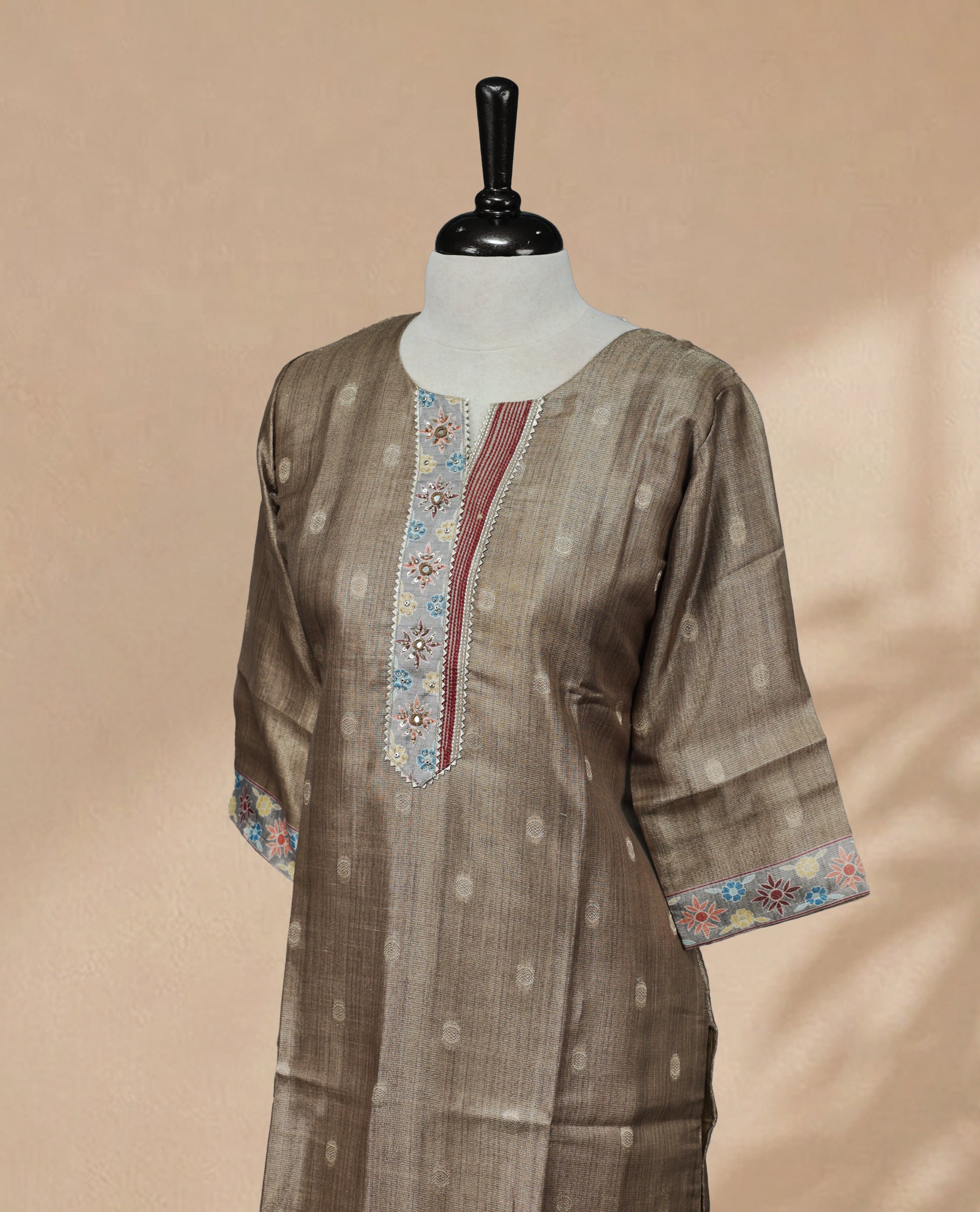 Khaki-colored tissue Kurti featuring gold circle motifs on the body, a U-shaped neckline adorned with thread and bead detailing, and 3/4 sleeves.