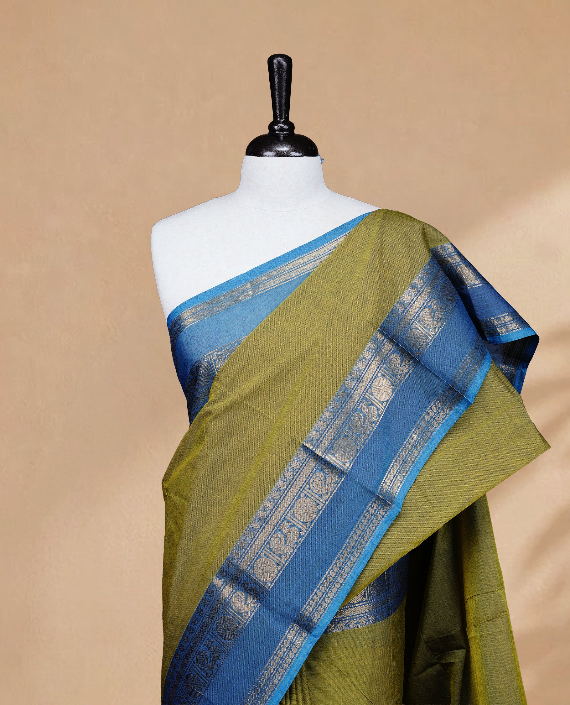 Olive colour Chettinad cotton saree featuring Elegant body, complemented by Contrast Blue colour with Gold zari border, paired with matching blouse piece.