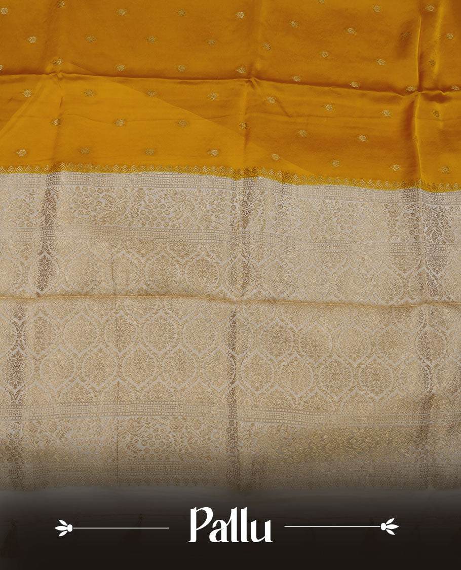 Yellow colour banaras satin crepe saree featuring gold zari motifs on body, with contrast cream colour border with gold zari pattern and paired with matching blouse.